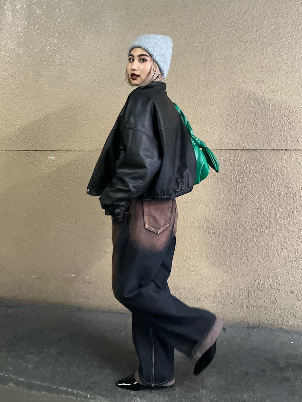 ブラック系のブルゾン、ブルー系のデニムパンツ、ホワイト系のTシャツ/カットソーを着用したレディースの冬コーディネートの2枚目の写真