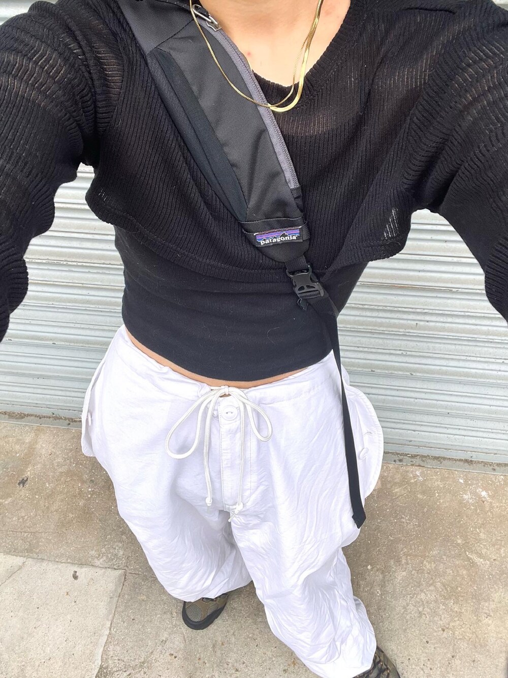 ブラック系のTシャツ/カットソー、ホワイト系のパンツ、グレー系のスニーカーを着用したレディースの夏コーディネートの3枚目の写真