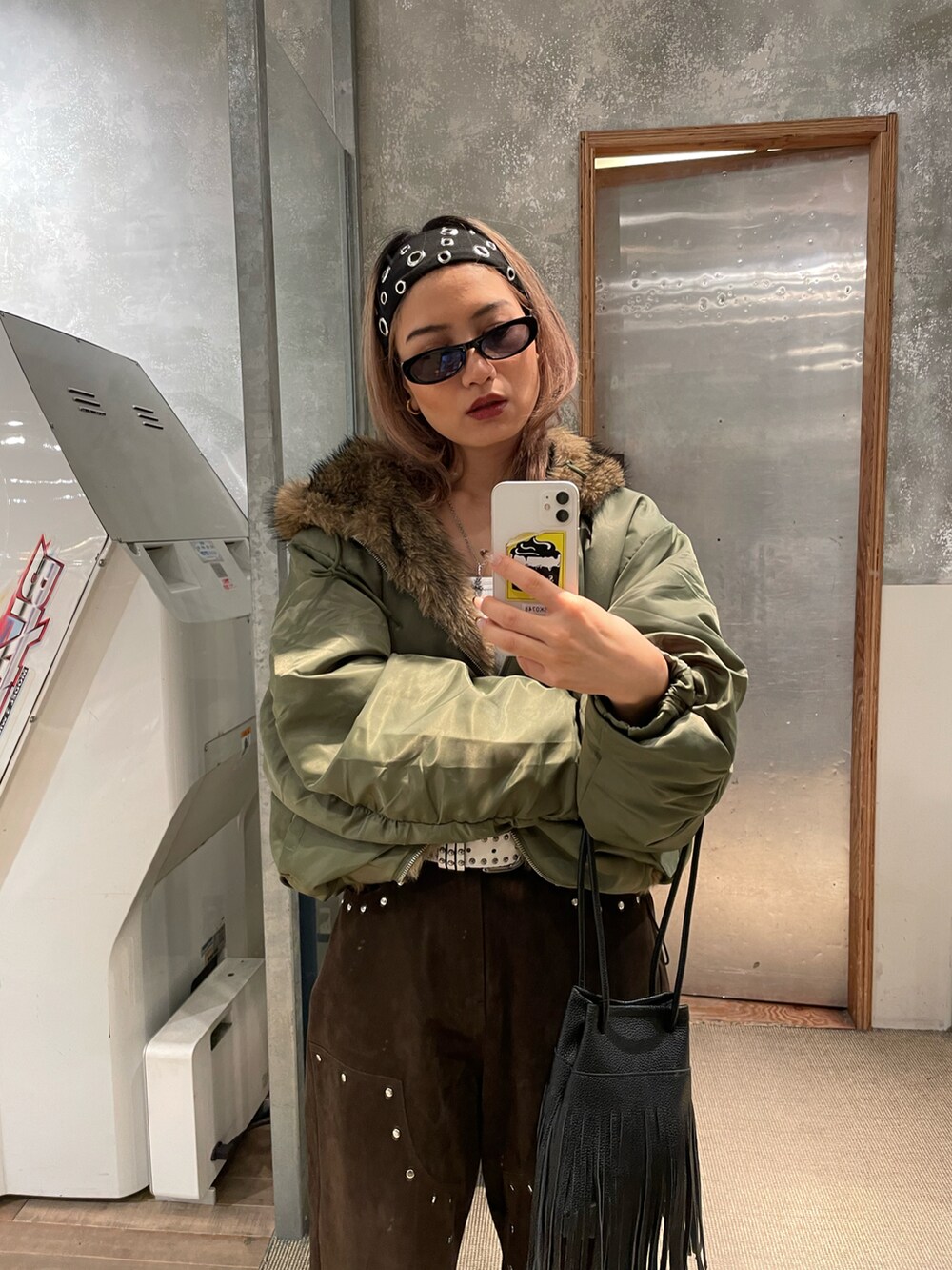 イエロー系のパンツ、グリーン系のブルゾンを着用したレディースの秋コーディネートの2枚目の写真