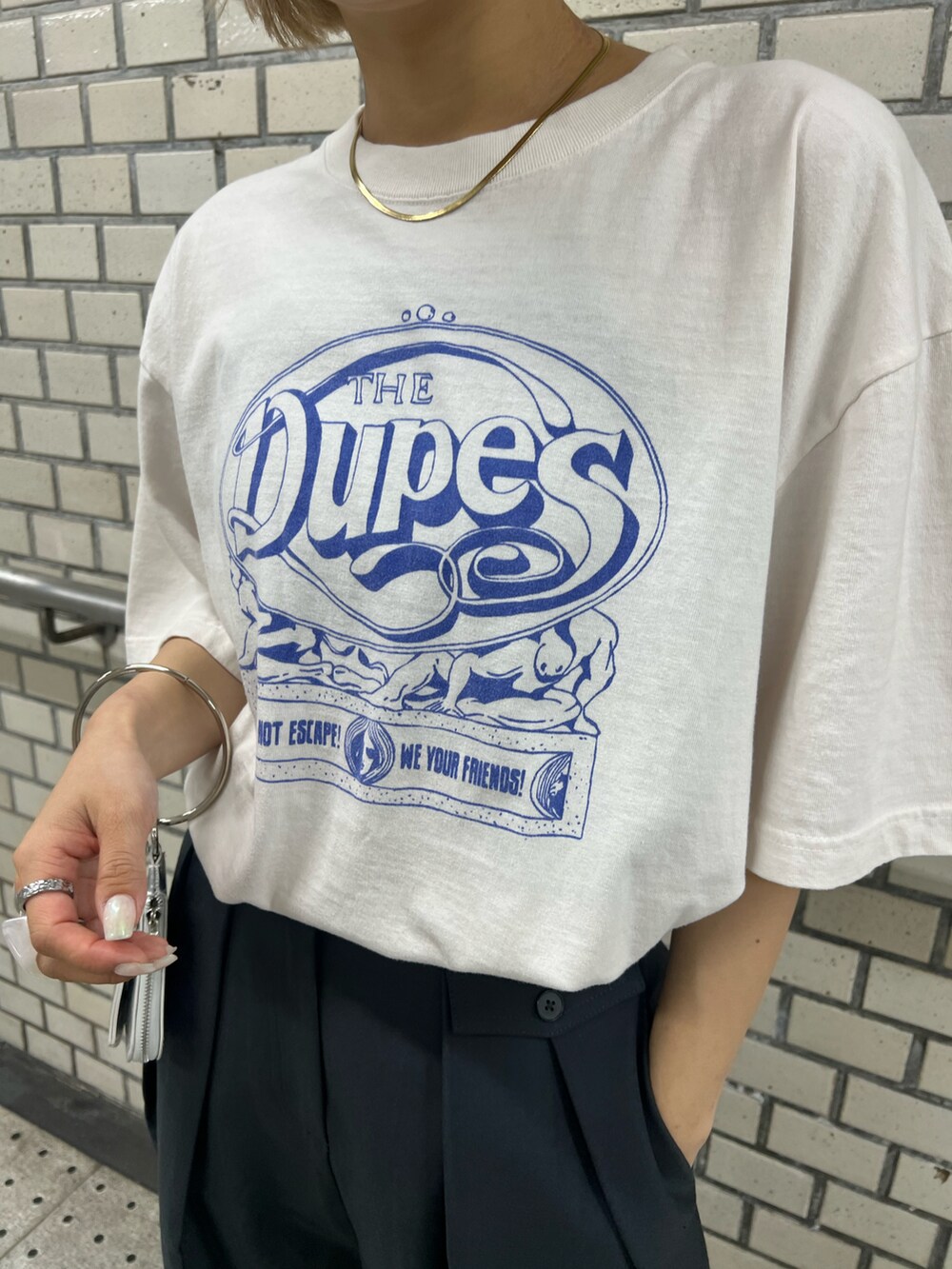 ブラック系のブーツ、ブルー系のスラックス、ホワイト系のTシャツ/カットソーを着用したレディースの夏コーディネートの5枚目の写真