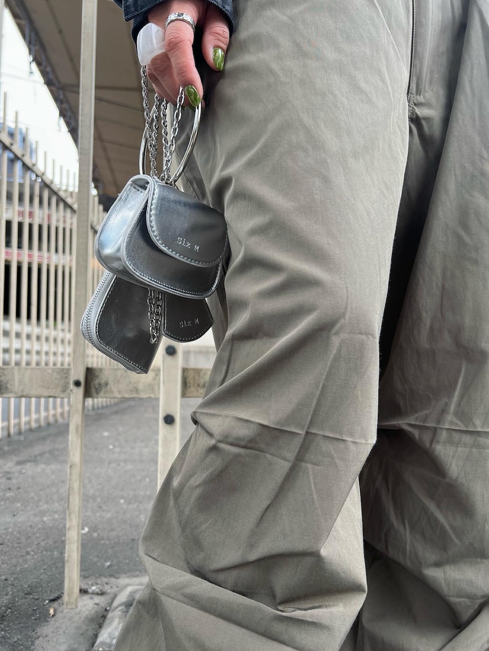 ホワイト系のカーゴパンツ、ブラック系のデニムジャケット、シルバー系のショルダーバッグを着用したレディースの春コーディネートの4枚目の写真