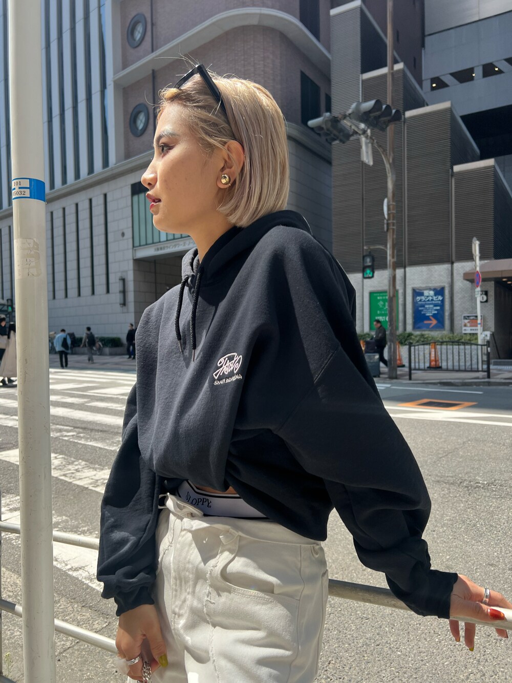 ブルー系のデニムパンツ、シルバー系のショルダーバッグ、グレー系のパーカーを着用したレディースの春コーディネートの4枚目の写真