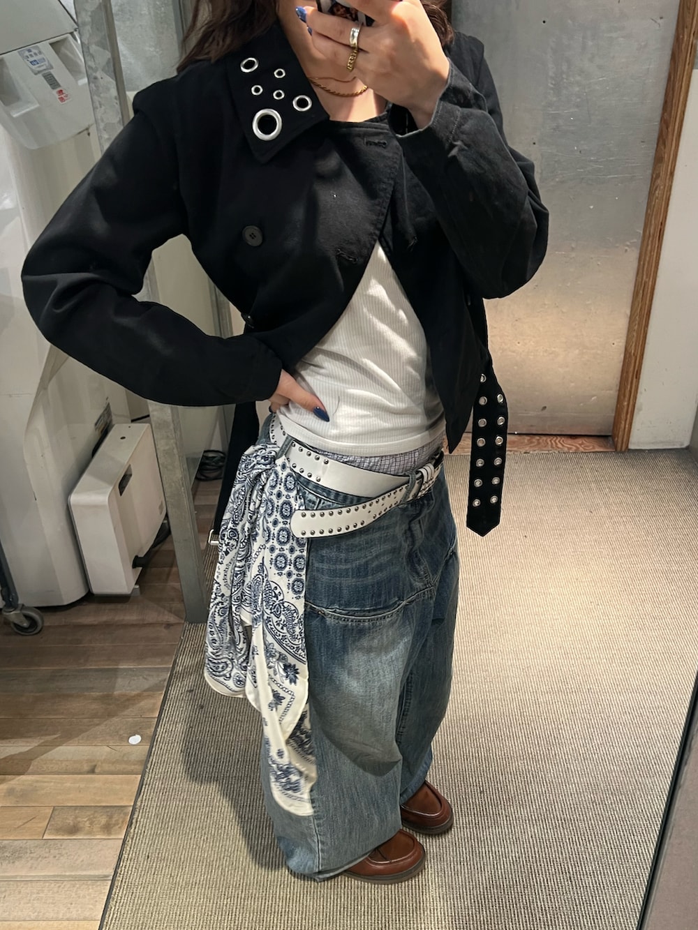 ブルー系のデニムパンツ、ブラック系のピーコートを着用したレディースの春コーディネートの2枚目の写真