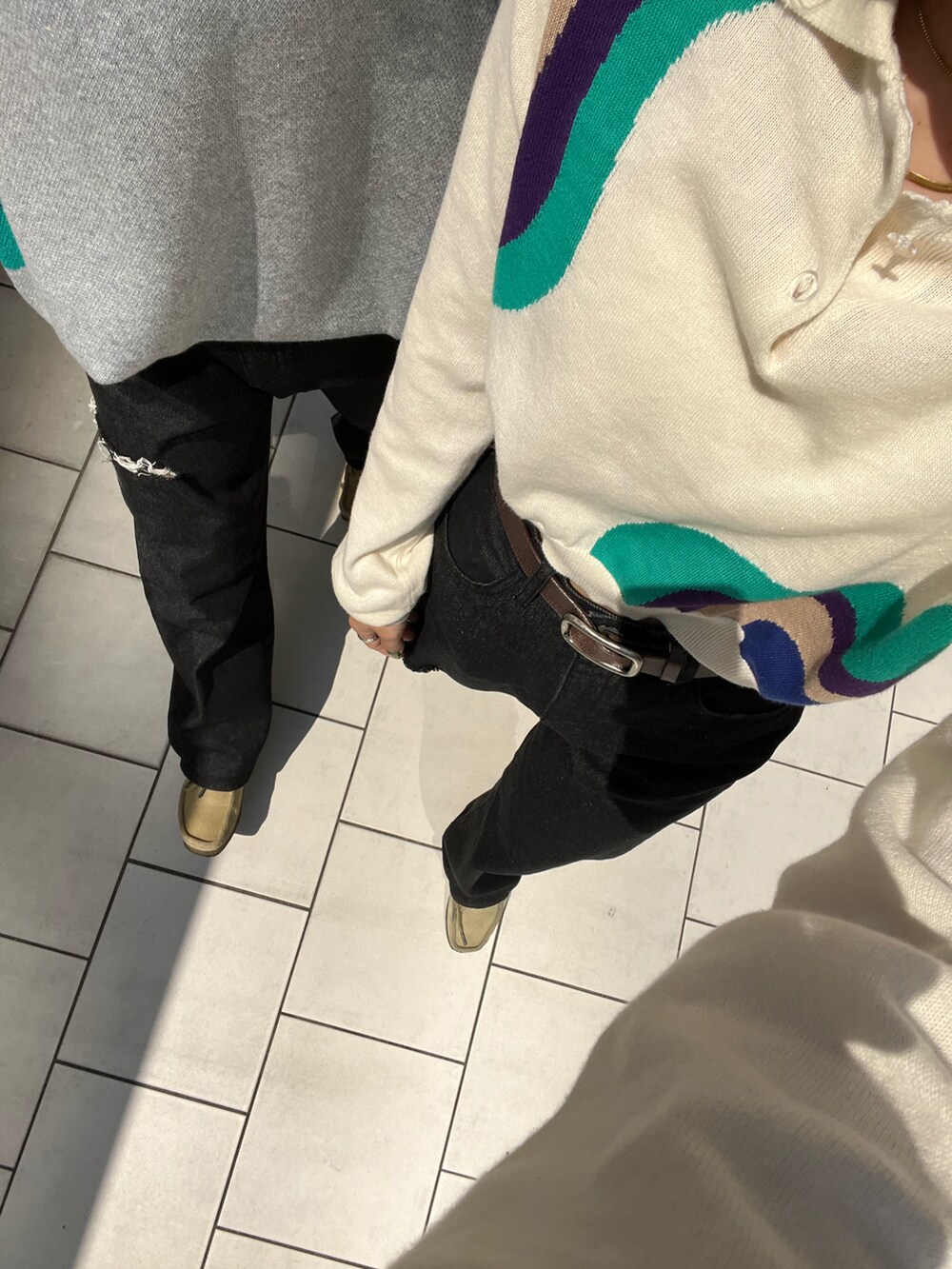 ブラック系のショルダーバッグ、ホワイト系のポロシャツ、ブラック系のデニムパンツを着用したレディースの春コーディネートの3枚目の写真