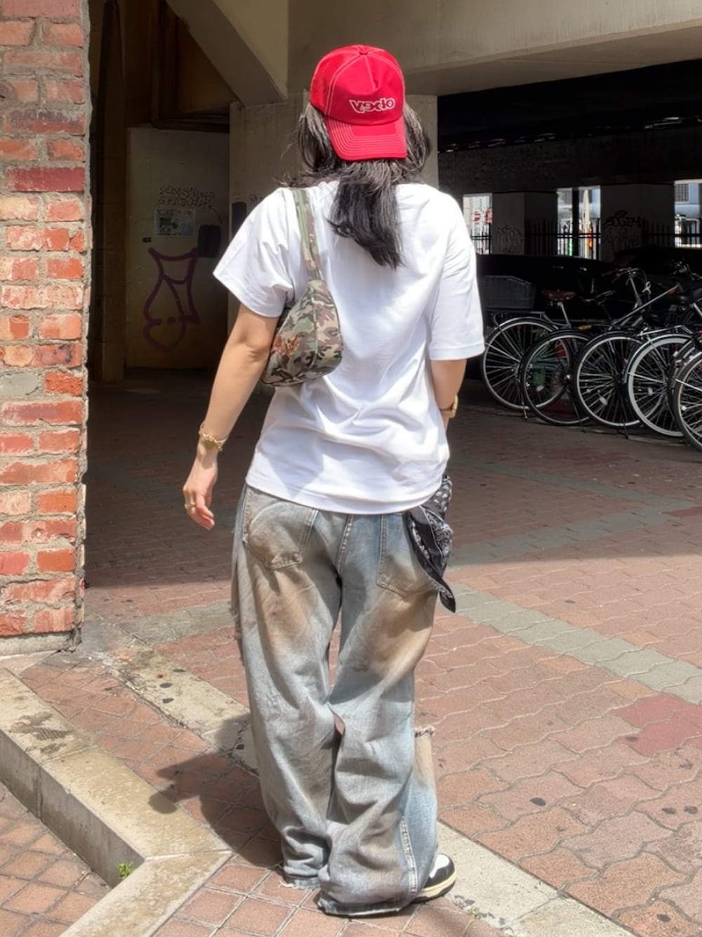 ホワイト系のTシャツ/カットソー、ブルー系のデニムパンツ、ブラウン系のショルダーバッグを着用したレディースの春コーディネートの2枚目の写真
