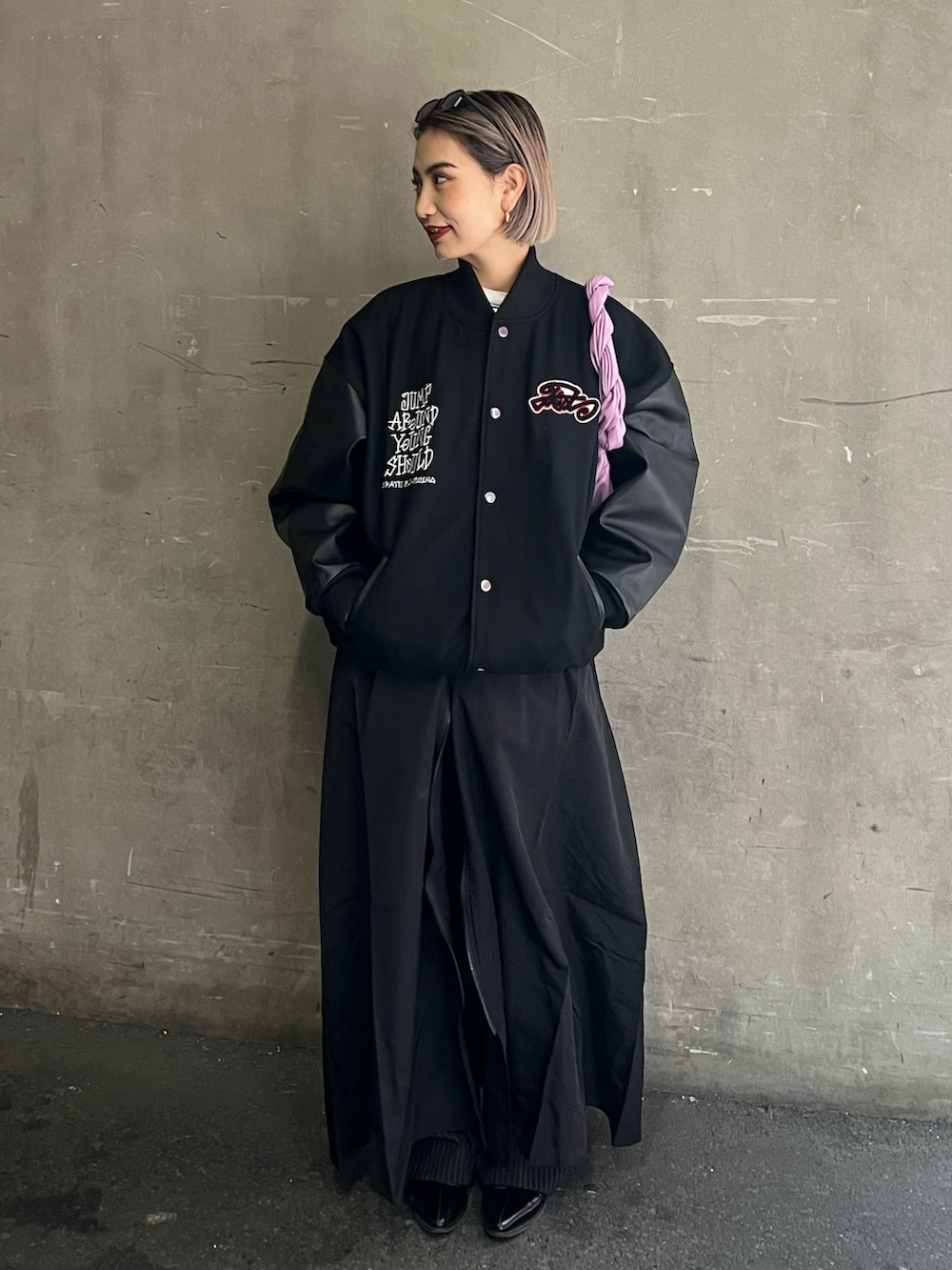 ブラック系のスタジャン、ブラック系のワンピース/ドレス、グリーン系のハンドバッグを着用したレディースの冬コーディネートの2枚目の写真