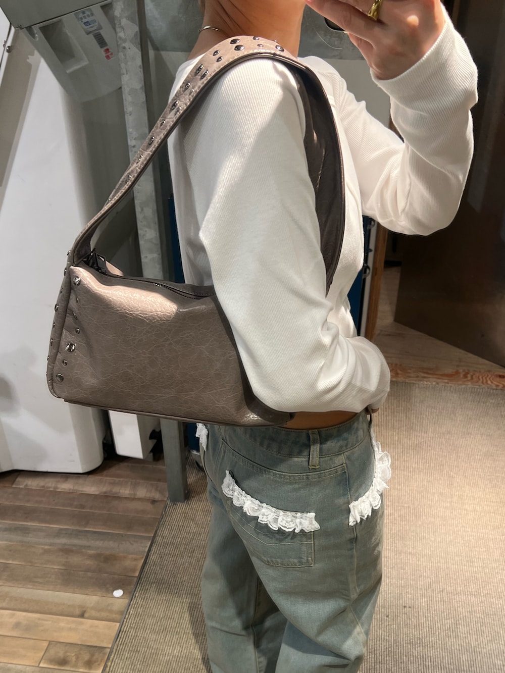 ブルー系のデニムパンツ、ホワイト系のTシャツ/カットソー、ブラック系のショルダーバッグを着用したレディースの春コーディネートの5枚目の写真