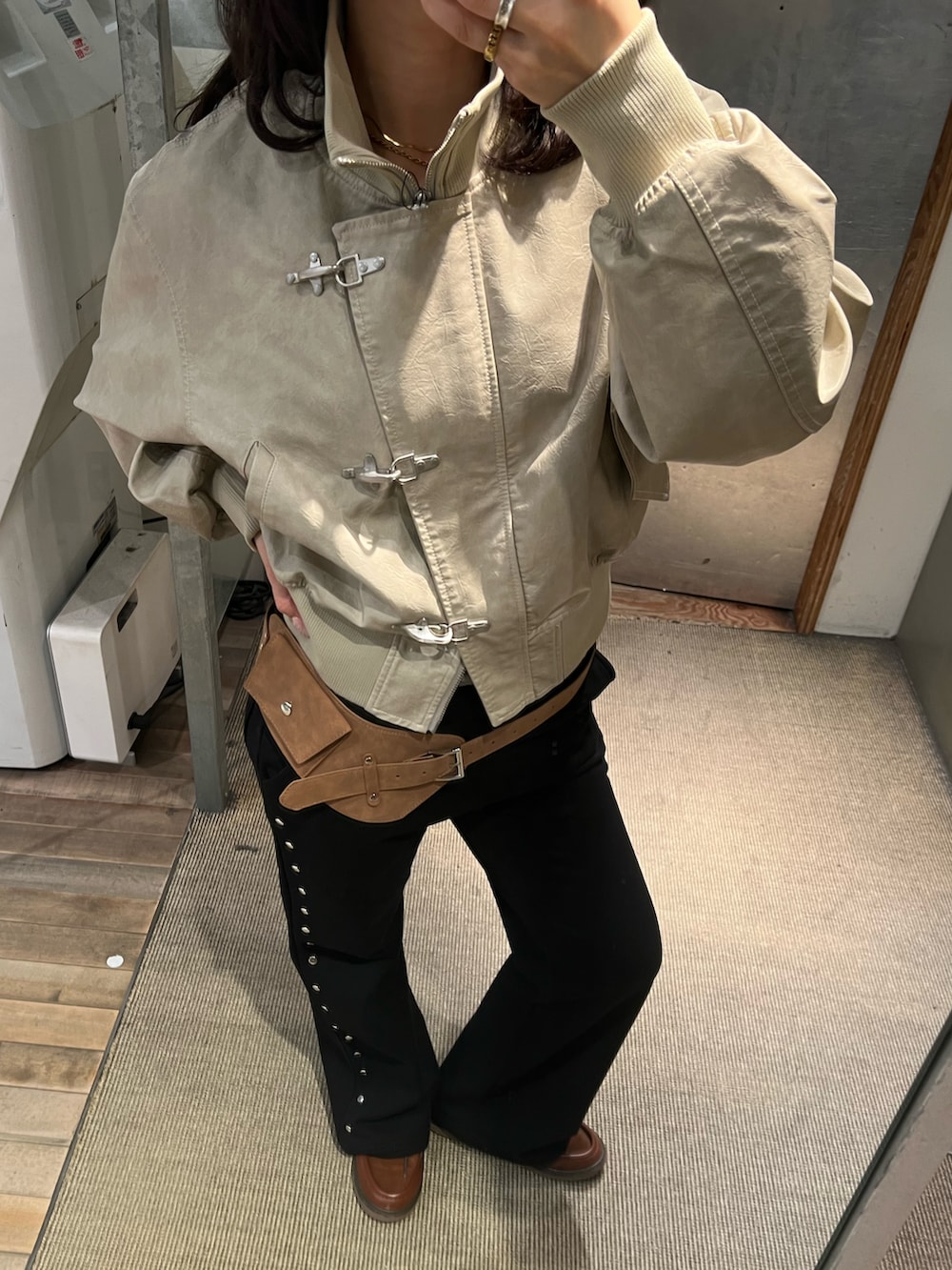 ホワイト系のブルゾン、グレー系のスウェットパンツ、ベージュ系のベルトを着用したレディースの冬コーディネートの2枚目の写真