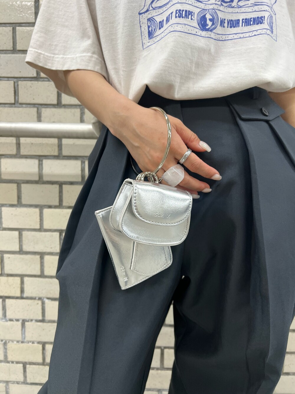 ブラック系のブーツ、ブルー系のスラックス、ホワイト系のTシャツ/カットソーを着用したレディースの夏コーディネートの4枚目の写真