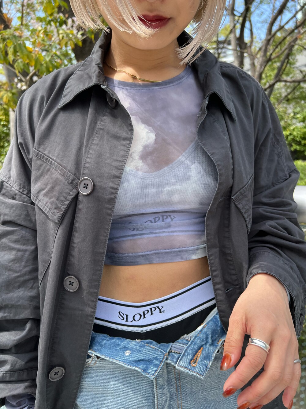 ブルー系のデニムパンツ、グリーン系のその他アウター、ホワイト系のその他パンツを着用したレディースの春コーディネートの2枚目の写真