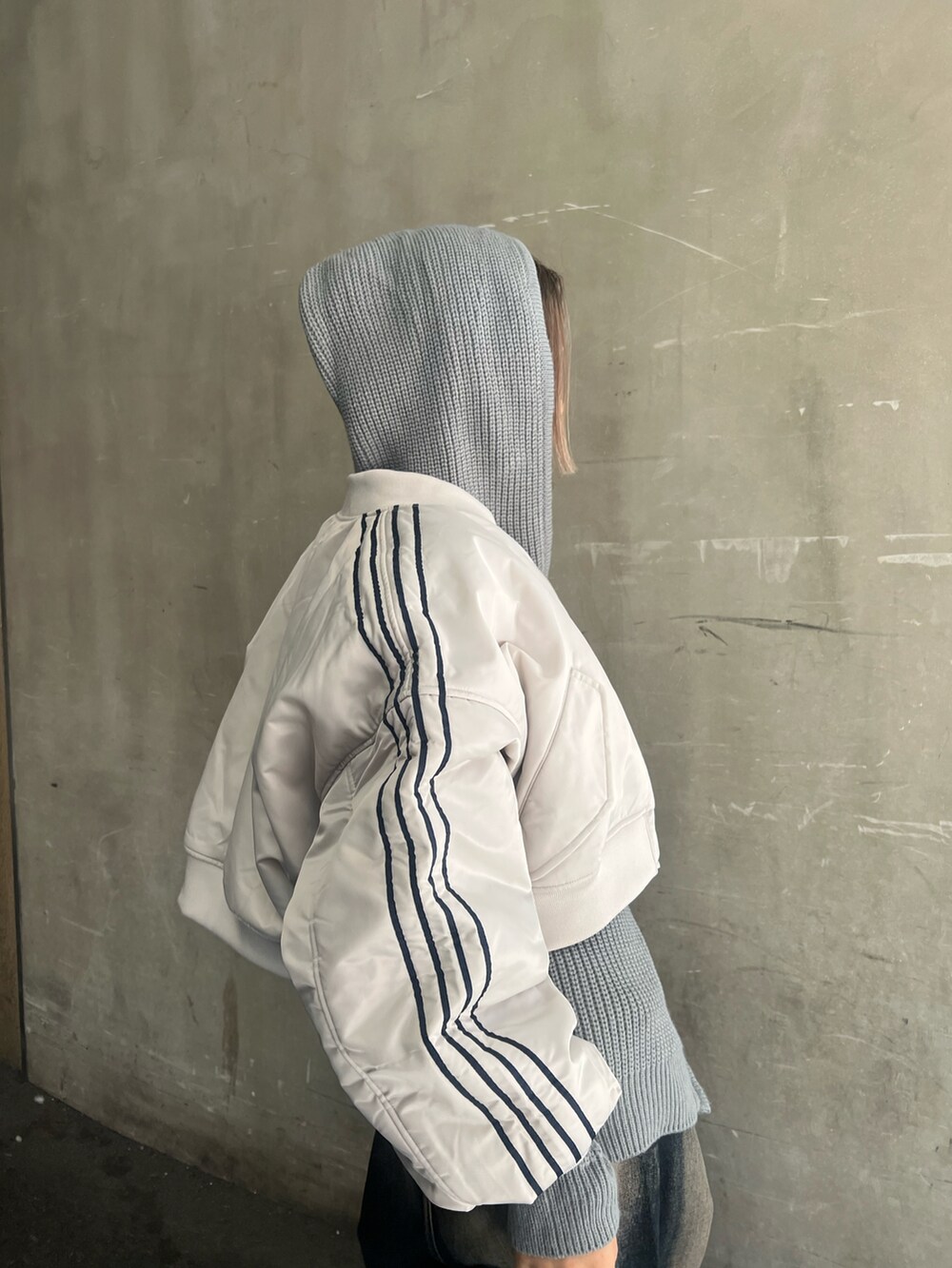 ブルー系のデニムパンツ、グレー系のパーカー、ホワイト系のMA-1を着用したレディースの冬コーディネートの4枚目の写真