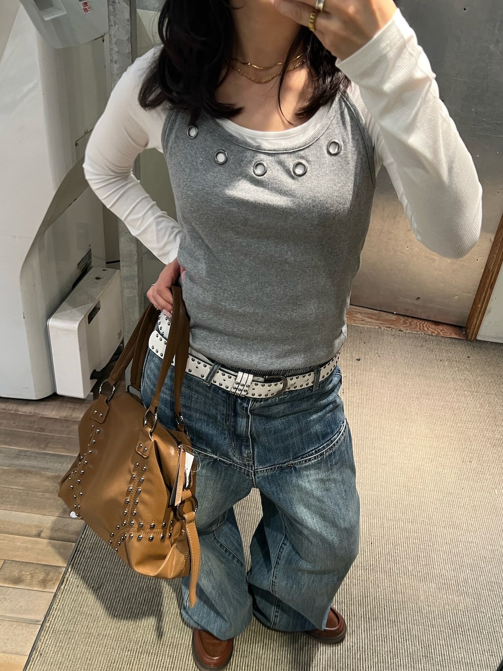 ブルー系のデニムパンツ、グレー系のTシャツ/カットソー、ブラウン系のボストンバッグを着用したレディースの冬コーディネートの2枚目の写真