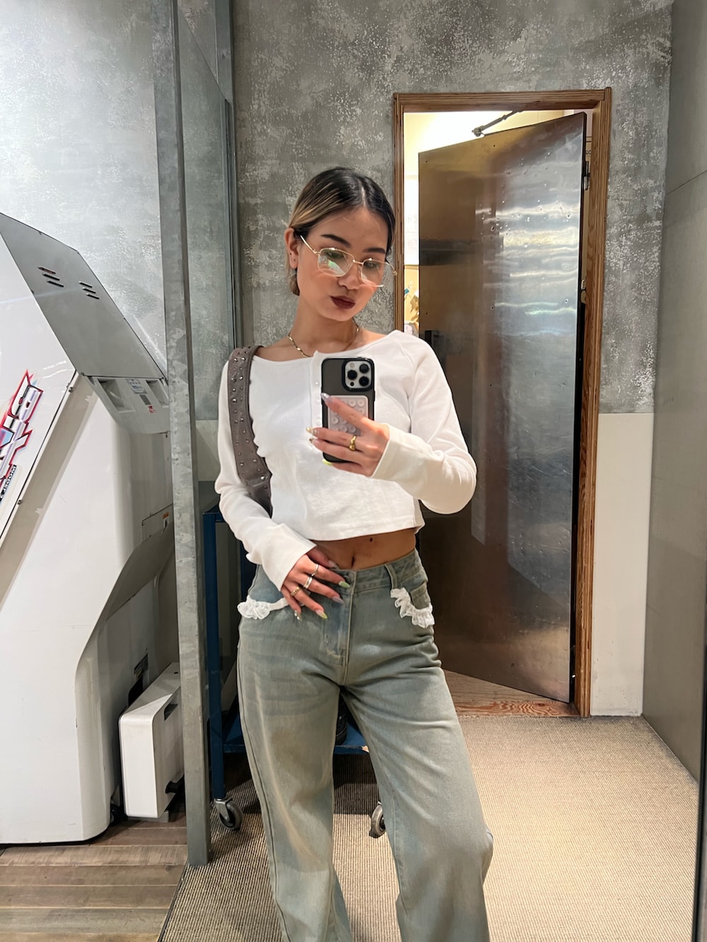 ブルー系のデニムパンツ、ホワイト系のTシャツ/カットソー、ブラック系のショルダーバッグを着用したレディースの春コーディネートの2枚目の写真