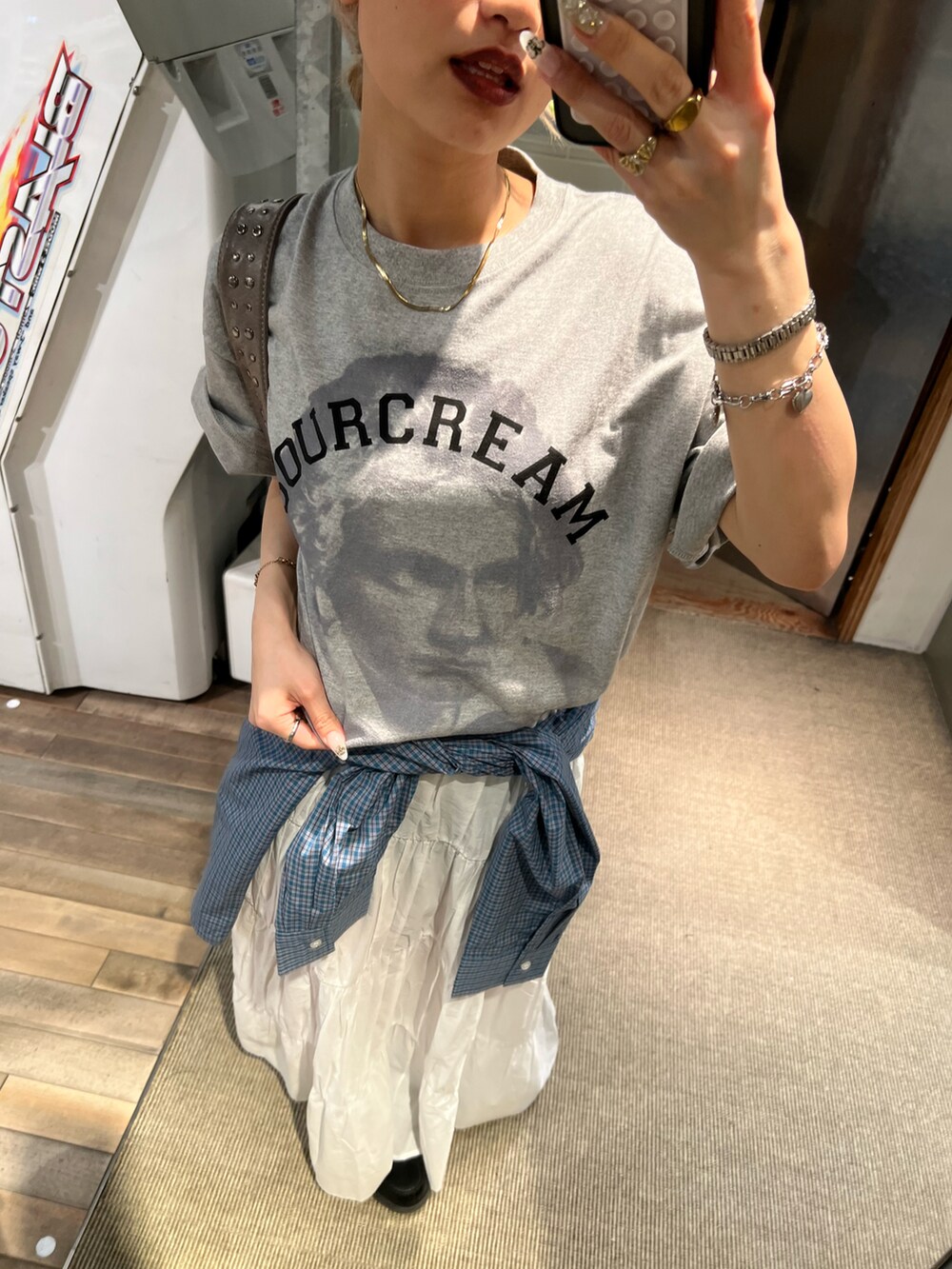 ホワイト系のスカート、ブルー系のシャツ/ブラウス、グレー系のTシャツ/カットソーを着用したレディースの春コーディネートの2枚目の写真