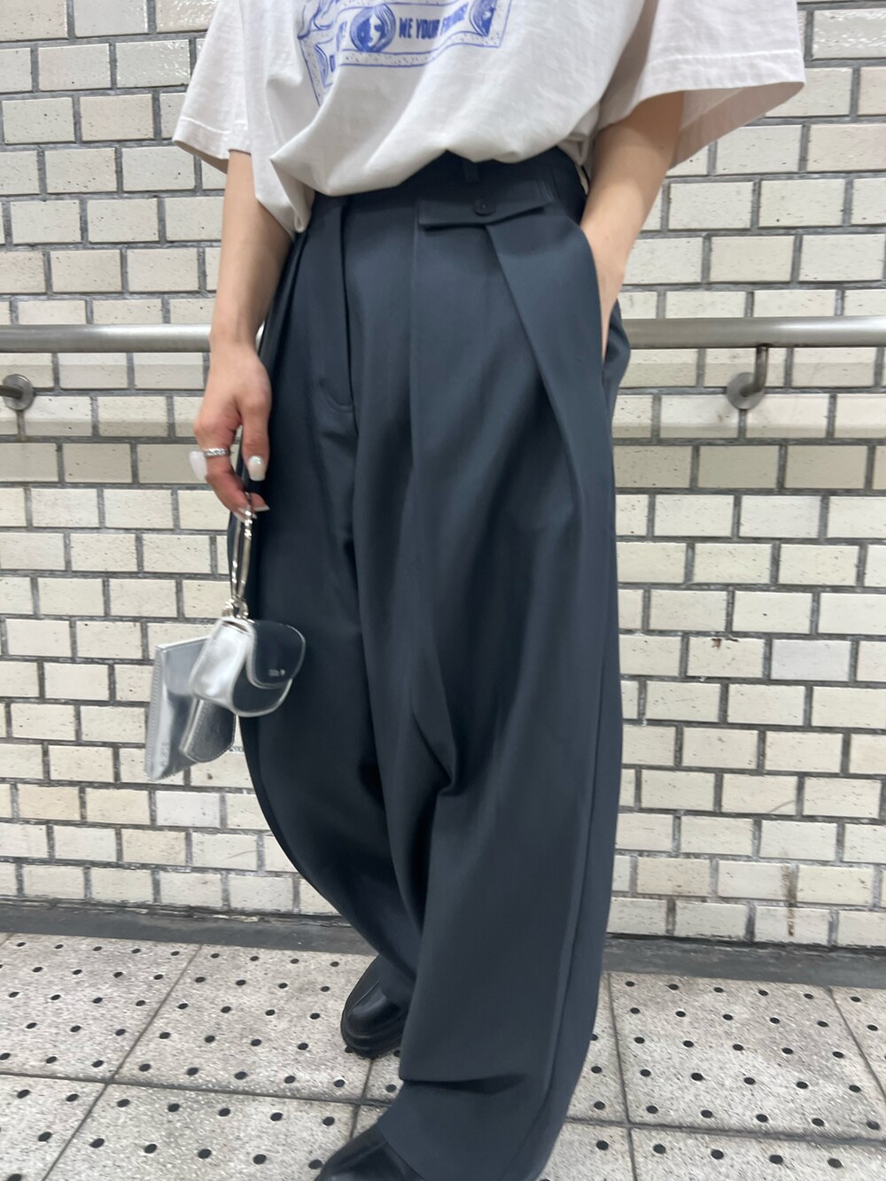 ブラック系のブーツ、ブルー系のスラックス、ホワイト系のTシャツ/カットソーを着用したレディースの夏コーディネートの3枚目の写真