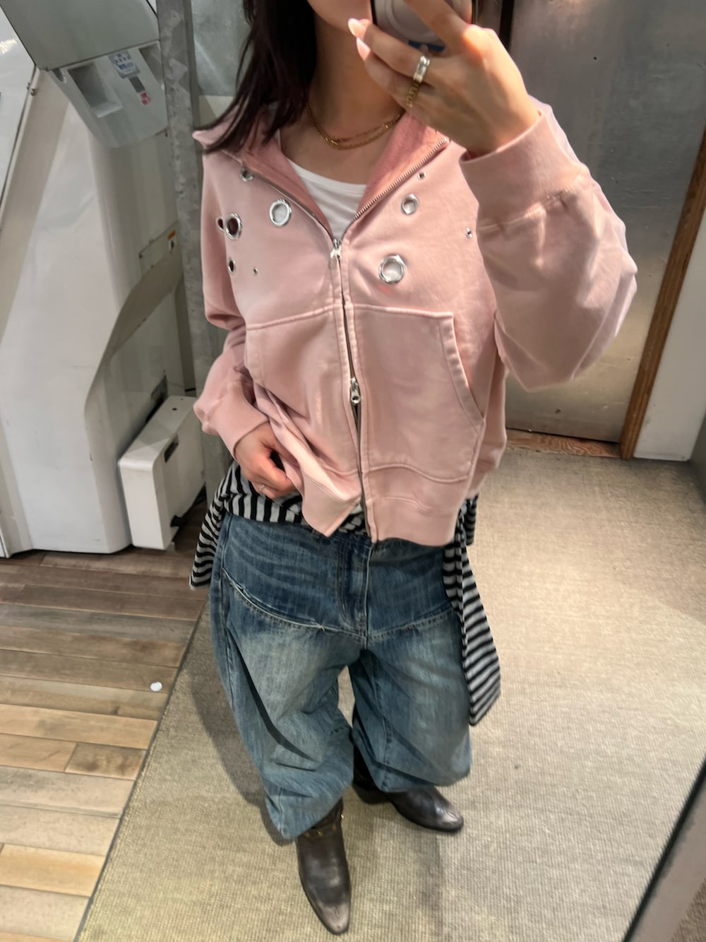 ピンク系のパーカー、ブルー系のデニムパンツを着用したレディースの冬コーディネートの3枚目の写真