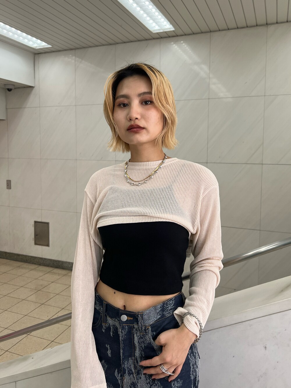 グレー系のキャミソール、ホワイト系のTシャツ/カットソー、ブルー系のデニムパンツを着用したレディースの夏コーディネートの2枚目の写真