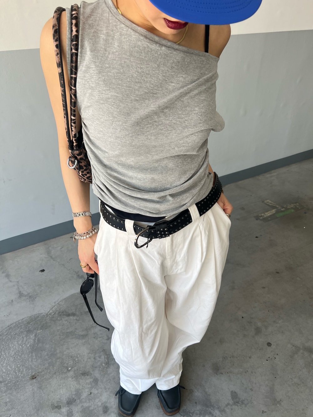 ホワイト系のタンクトップ、ホワイト系のパンツ、ブルー系のシューズを着用したレディースの夏コーディネートの2枚目の写真