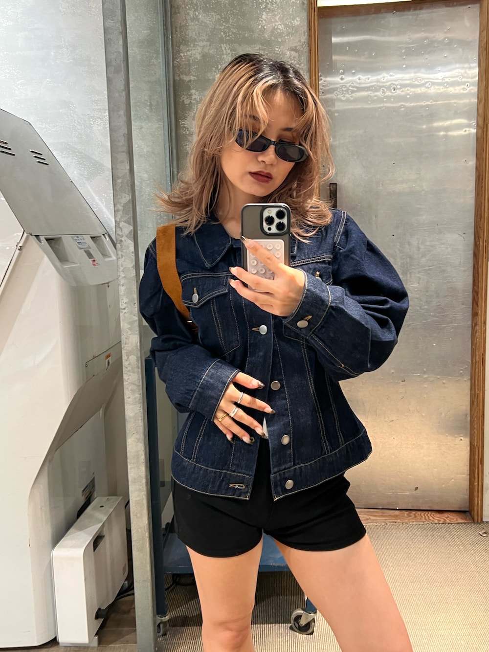 ブラウン系のブーツ、ブラック系のその他パンツ、ブルー系のデニムジャケットを着用したレディースの秋コーディネートの3枚目の写真