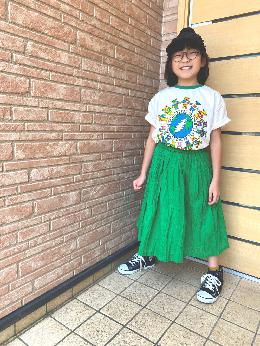 ブラック系のスニーカー、グリーン系のスカート、グリーン系のTシャツ/カットソーを着用したキッズの夏コーディネートの3枚目の写真