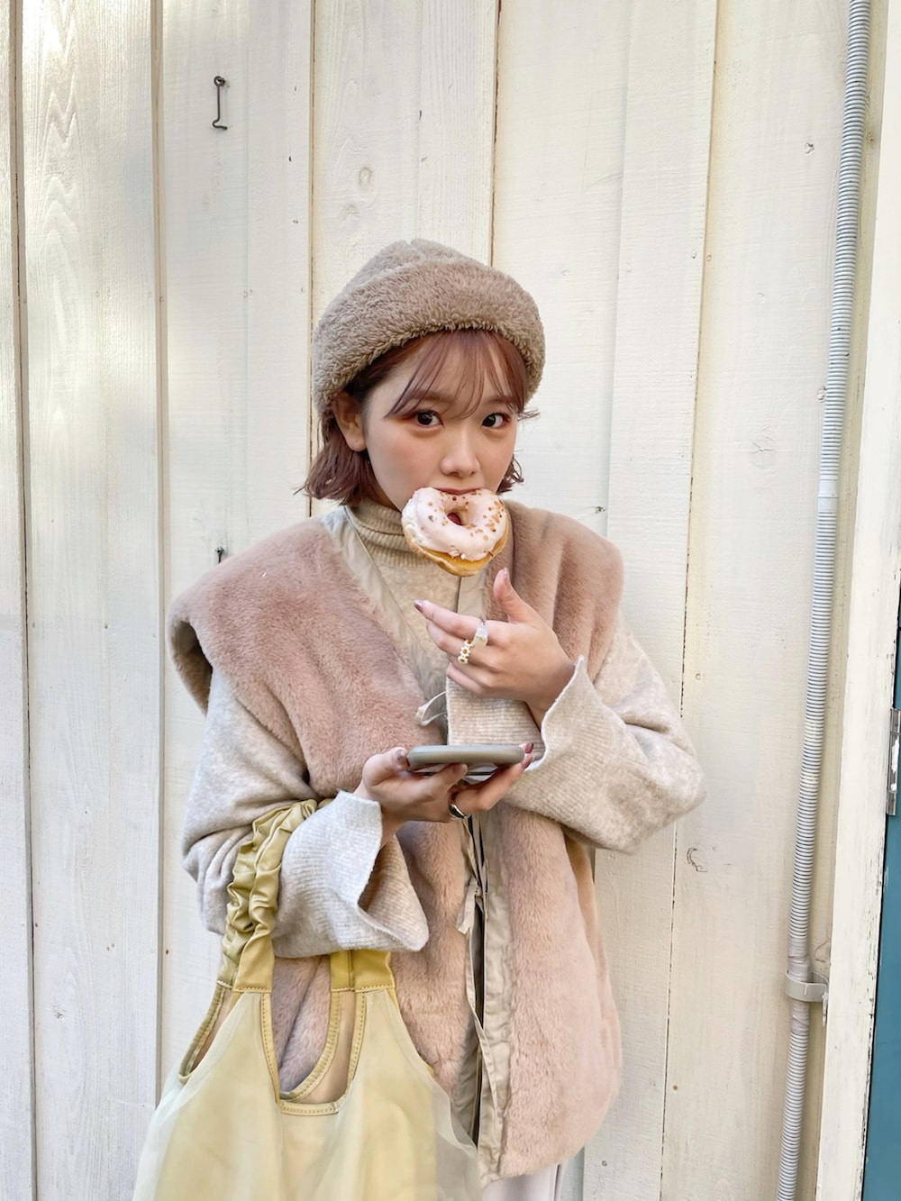 ベージュ系のミリタリージャケット、ホワイト系のニット/セーター、イエロー系のショルダーバッグを着用したレディースの冬コーディネートの2枚目の写真