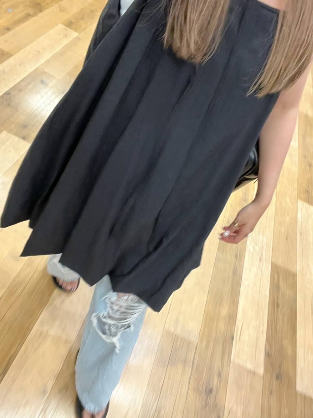 ブルー系のデニムパンツ、ブラック系のワンピース、ブラック系のサンダルを着用したレディースの夏コーディネートの2枚目の写真