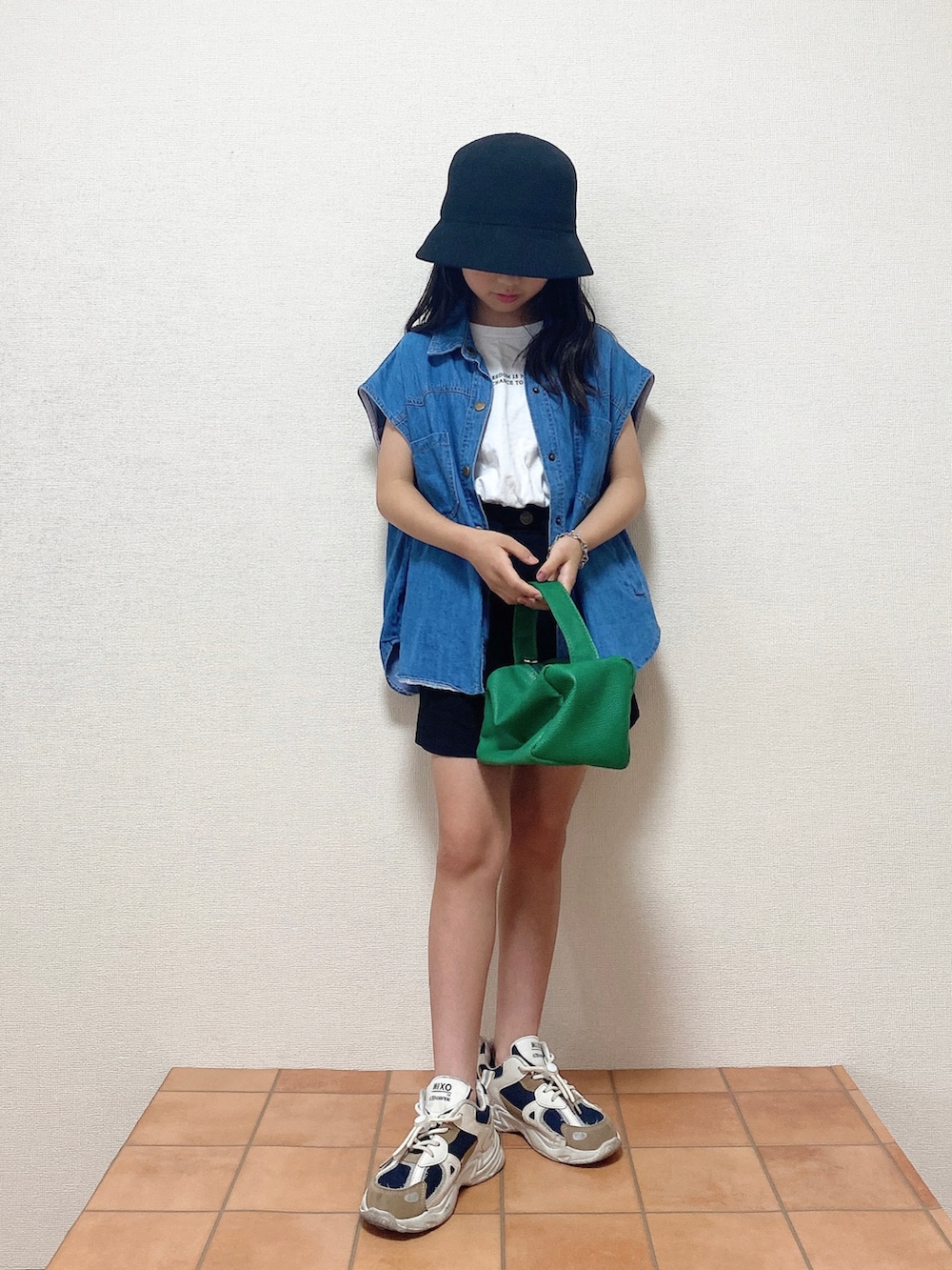 ブルー系のベスト、ホワイト系のTシャツ/カットソー、ブラック系のスカートを着用したキッズの夏コーディネートの2枚目の写真