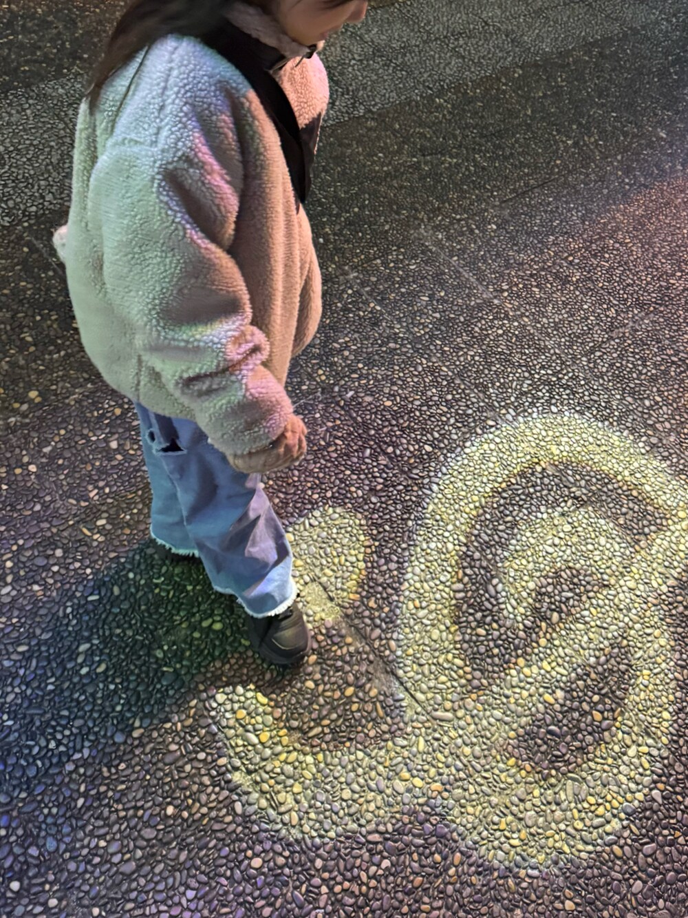 グレー系のブルゾン、ブルー系のデニムパンツ、ベージュ系の手袋を着用したキッズの冬コーディネートの2枚目の写真