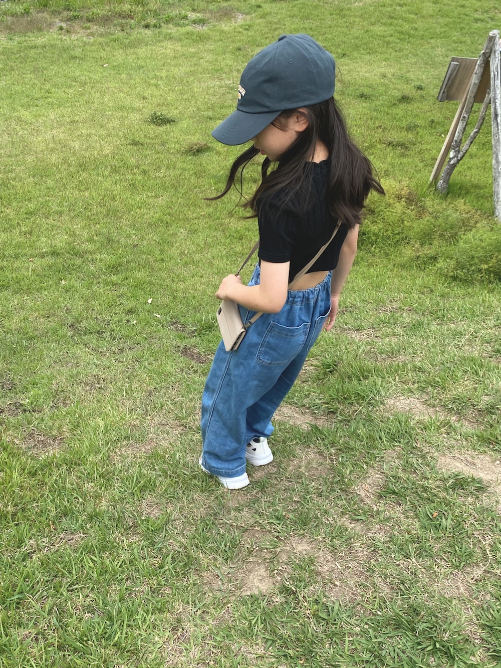 ブラック系のTシャツ/カットソー、ブルー系のデニムパンツ、グリーン系のキャップを着用したキッズの夏コーディネートの2枚目の写真