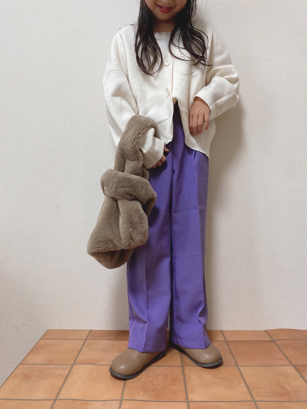 ブラウン系のブーツ、パープル系のパンツ、ホワイト系のカーディガン/ボレロを着用したキッズの秋コーディネートの2枚目の写真