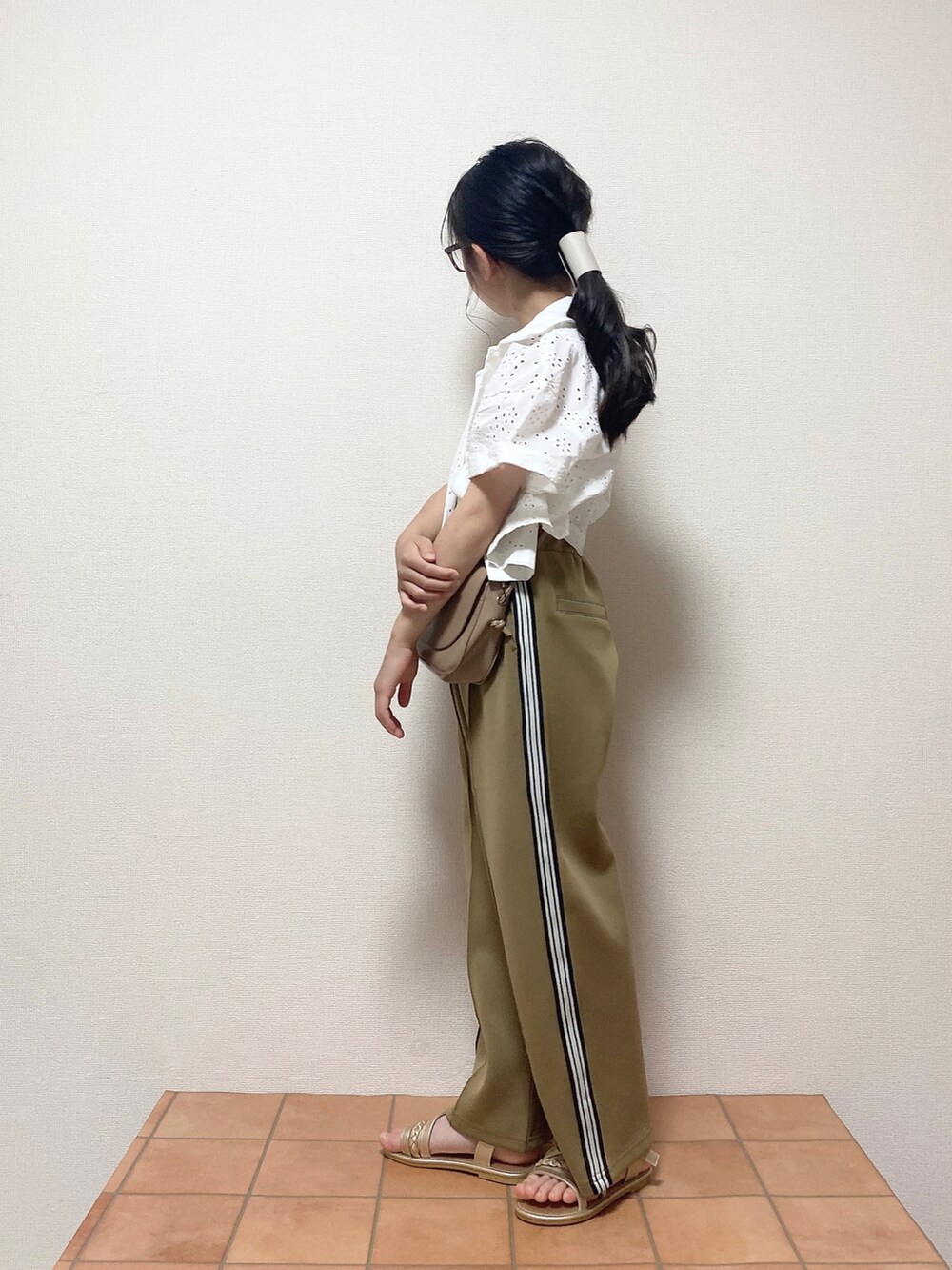 ベージュ系のその他パンツ、ホワイト系のシャツ/ブラウス、ベージュ系のショルダーバッグを着用したキッズの夏コーディネートの2枚目の写真