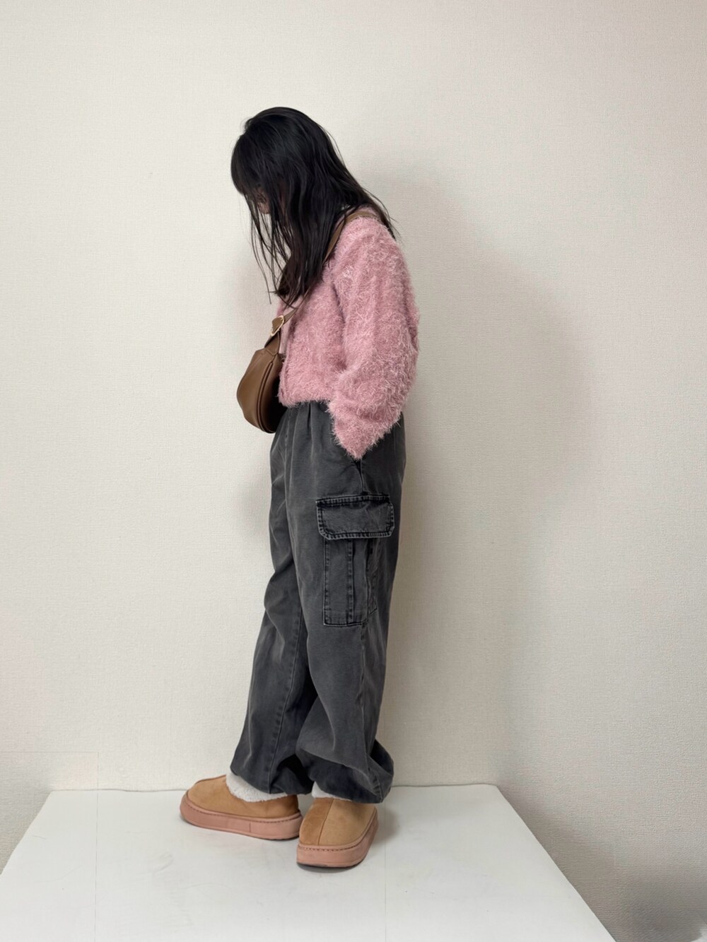 ピンク系のカーディガン/ボレロ、ブラック系のカーゴパンツを着用したキッズの冬コーディネートの2枚目の写真