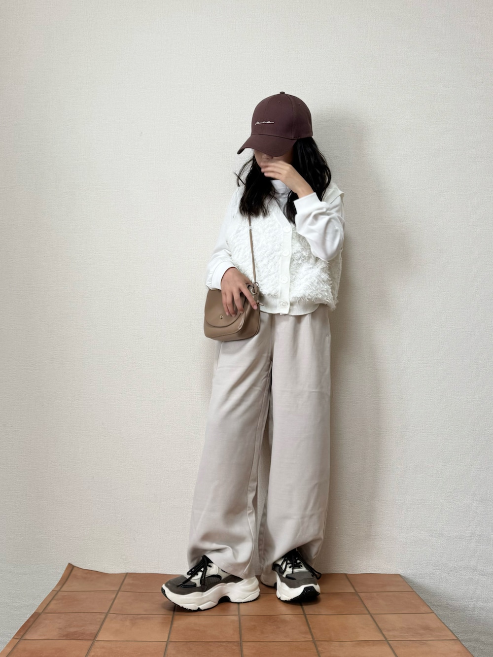 ホワイト系のベスト、ホワイト系のその他パンツ、ブラウン系のキャップを着用したキッズの秋コーディネートの2枚目の写真