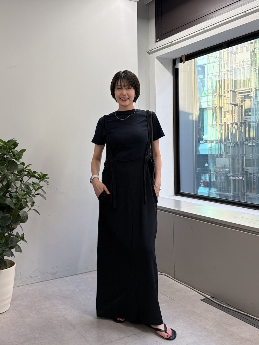 ブラック系のワンピース、ブラック系のトートバッグを着用したレディースの春コーディネートの3枚目の写真