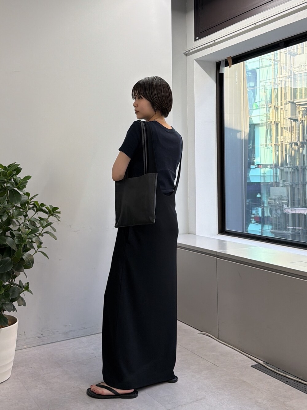 ブラック系のワンピース、ブラック系のトートバッグを着用したレディースの春コーディネートの2枚目の写真