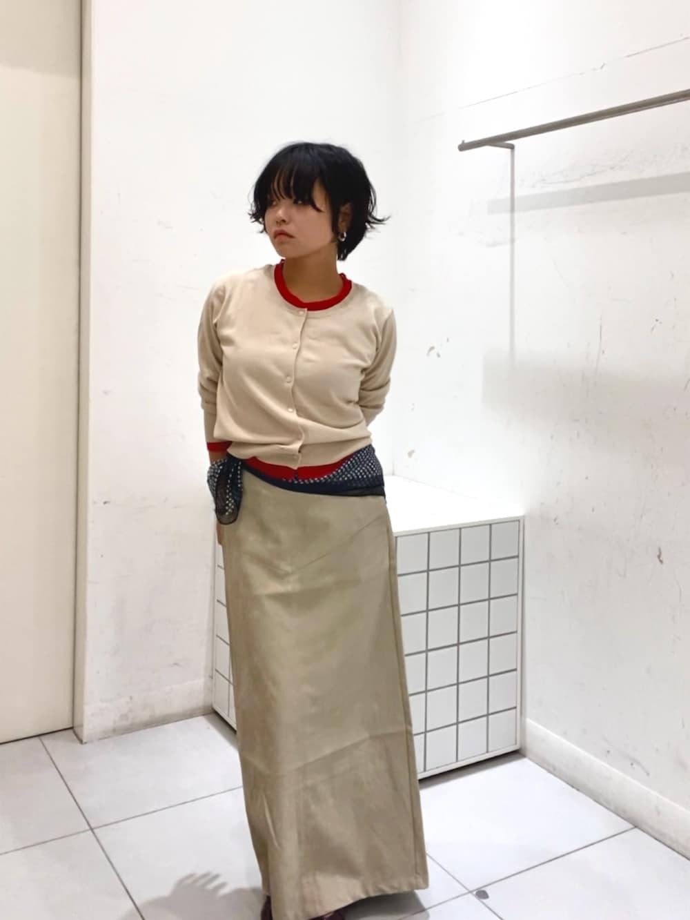 ベージュ系のニット/セーター、ベージュ系のスカートを着用したレディースの秋コーディネートの2枚目の写真