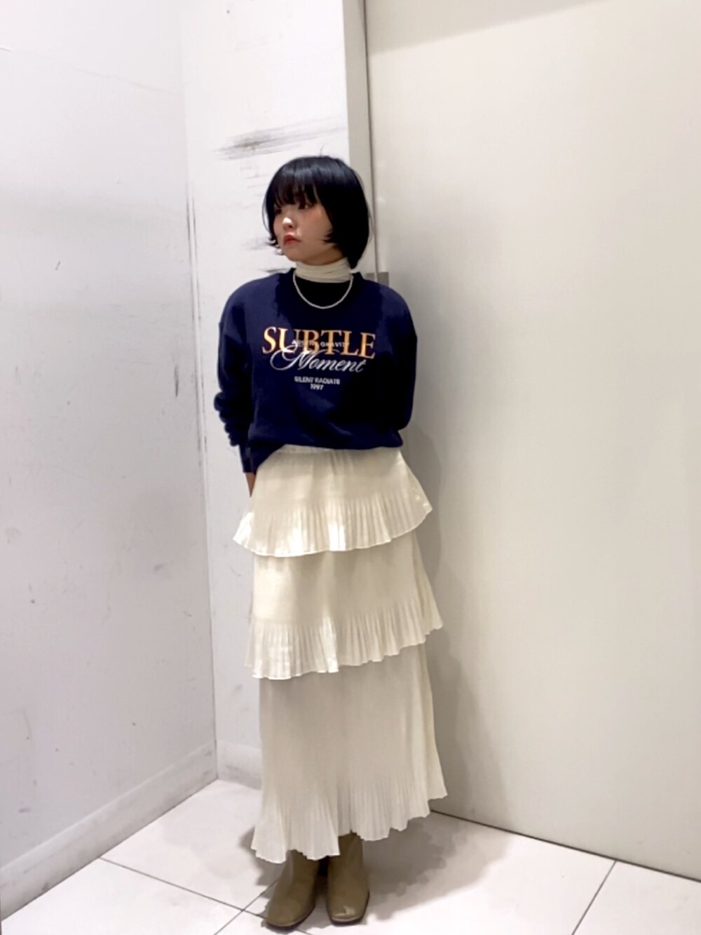 ホワイト系のスカート、ホワイト系のTシャツ/カットソー、ベージュ系のスウェットを着用したレディースの秋コーディネートの2枚目の写真