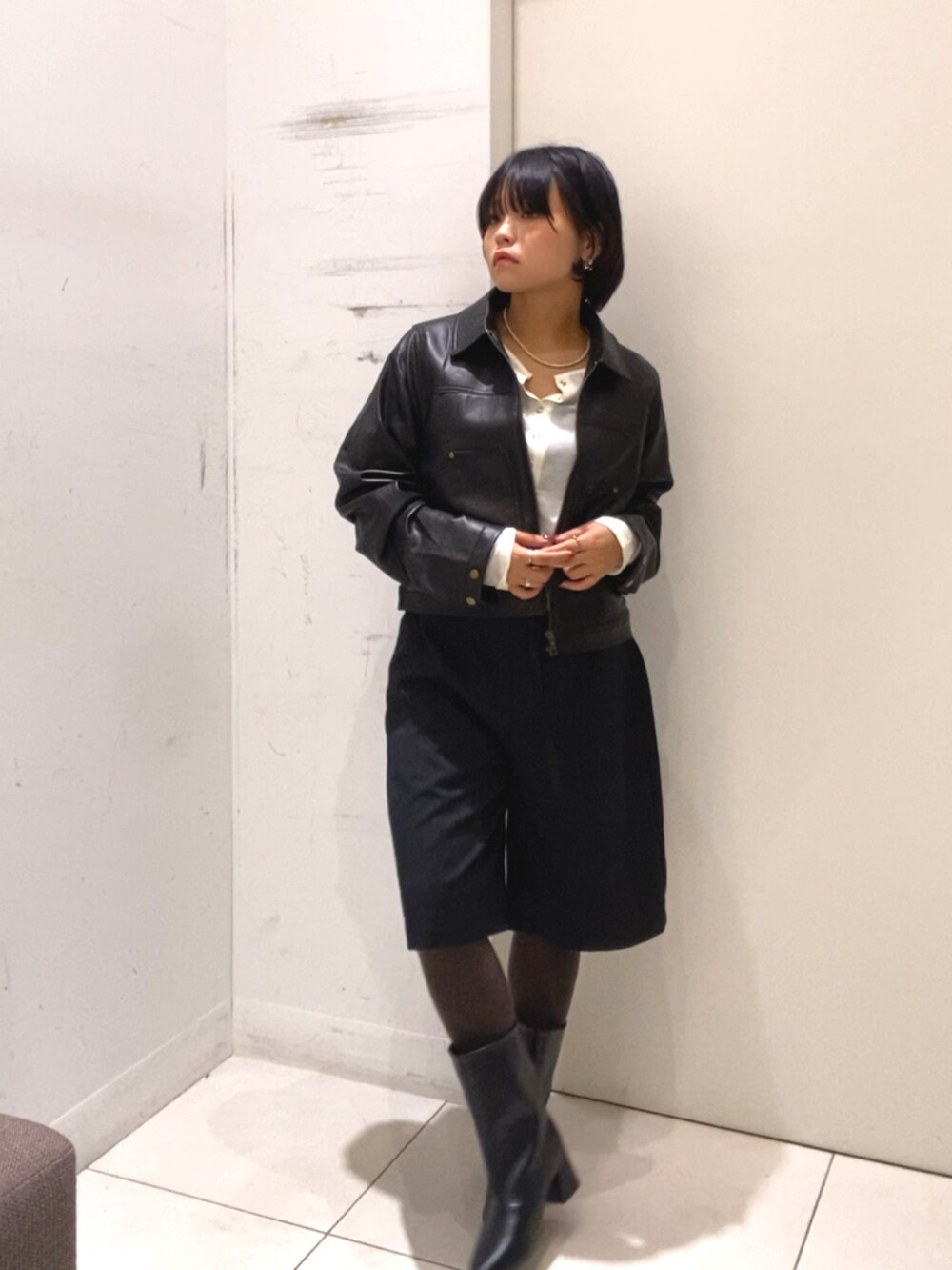 ブラック系のその他アウター、ブラック系のその他パンツ、ホワイト系のTシャツ/カットソーを着用したレディースの秋コーディネートの2枚目の写真