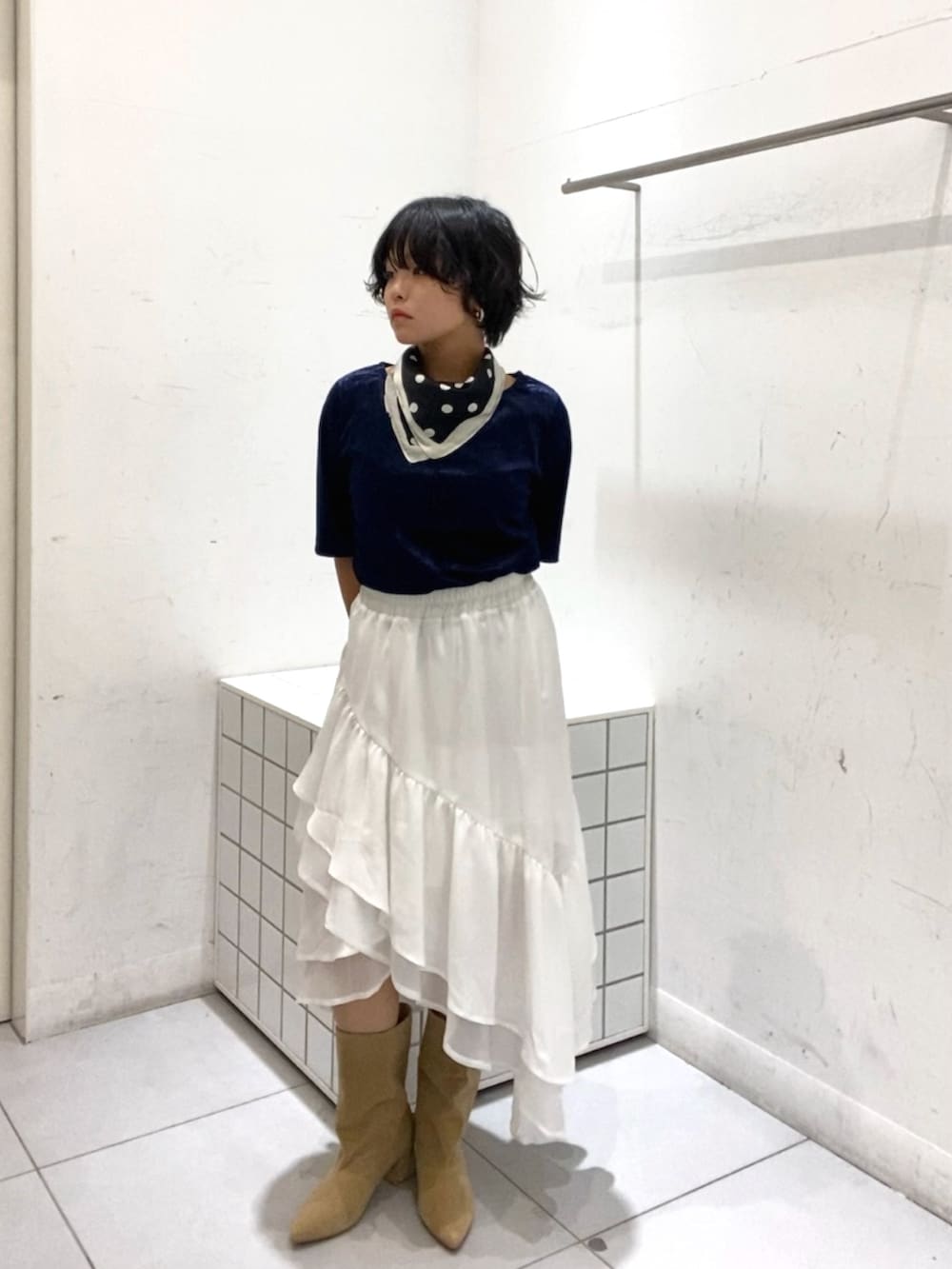 ベージュ系のブーツ、ホワイト系のスカート、ブルー系のTシャツ/カットソーを着用したレディースの秋コーディネートの3枚目の写真