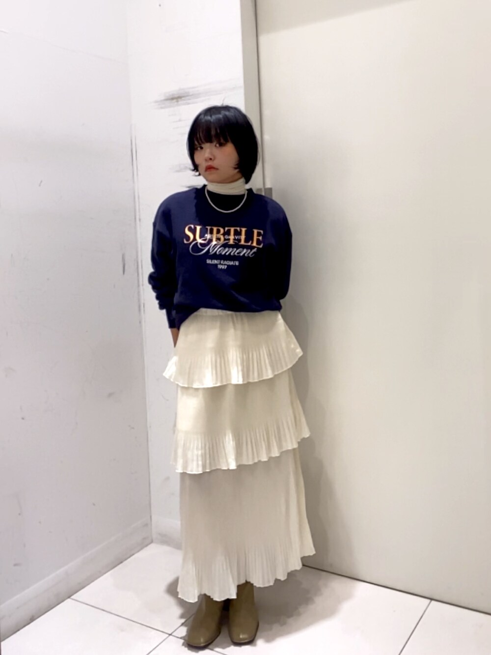 ホワイト系のスカート、ホワイト系のTシャツ/カットソー、ベージュ系のスウェットを着用したレディースの秋コーディネートの3枚目の写真