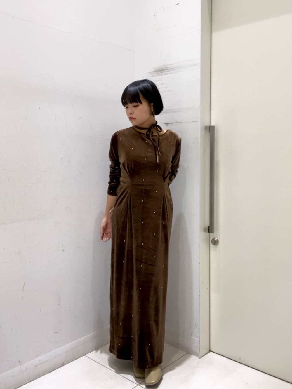 ブラウン系のワンピースを着用したレディースの冬コーディネートの2枚目の写真