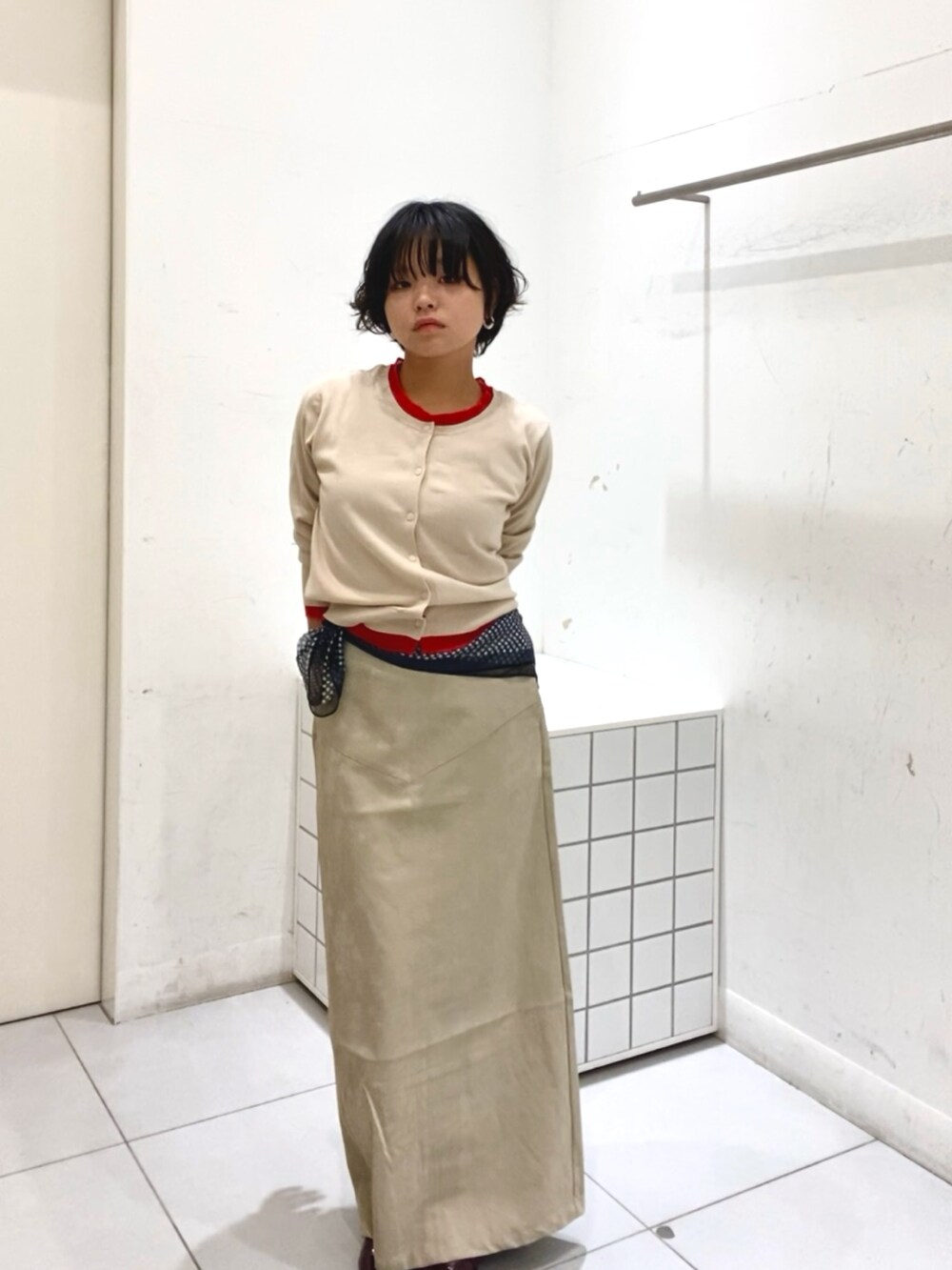 ベージュ系のニット/セーター、ベージュ系のスカートを着用したレディースの秋コーディネートの3枚目の写真