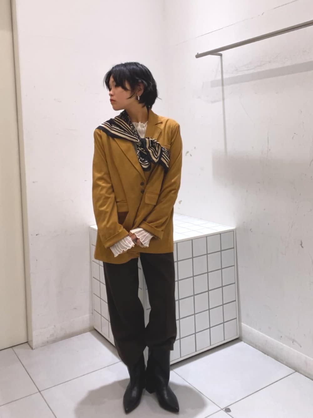 イエロー系のその他アウター、ブラウン系のその他パンツ、ブラック系のブーツを着用したレディースの秋コーディネートの3枚目の写真