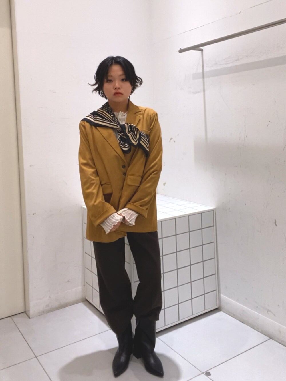 イエロー系のその他アウター、ブラウン系のその他パンツ、ブラック系のブーツを着用したレディースの秋コーディネートの2枚目の写真