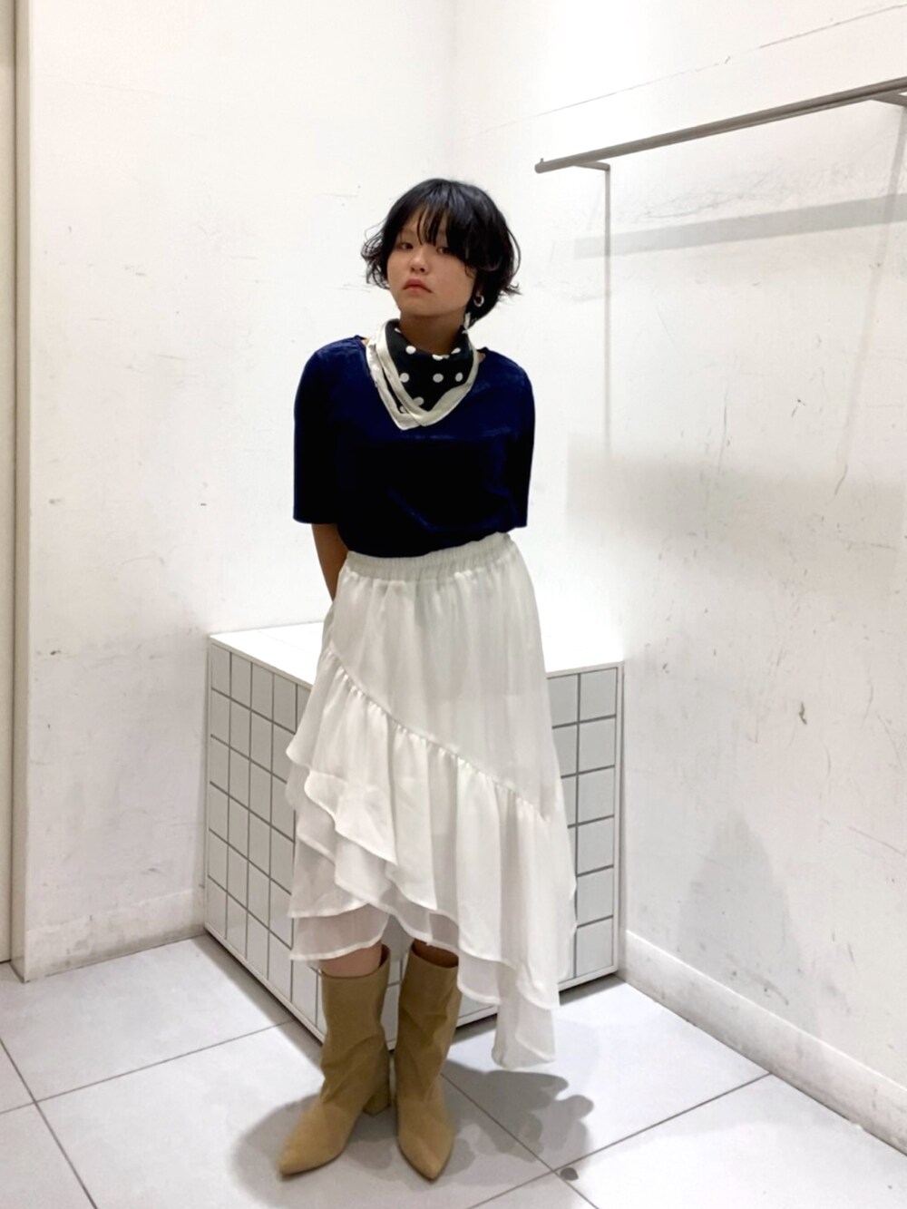 ベージュ系のブーツ、ホワイト系のスカート、ブルー系のTシャツ/カットソーを着用したレディースの秋コーディネートの2枚目の写真