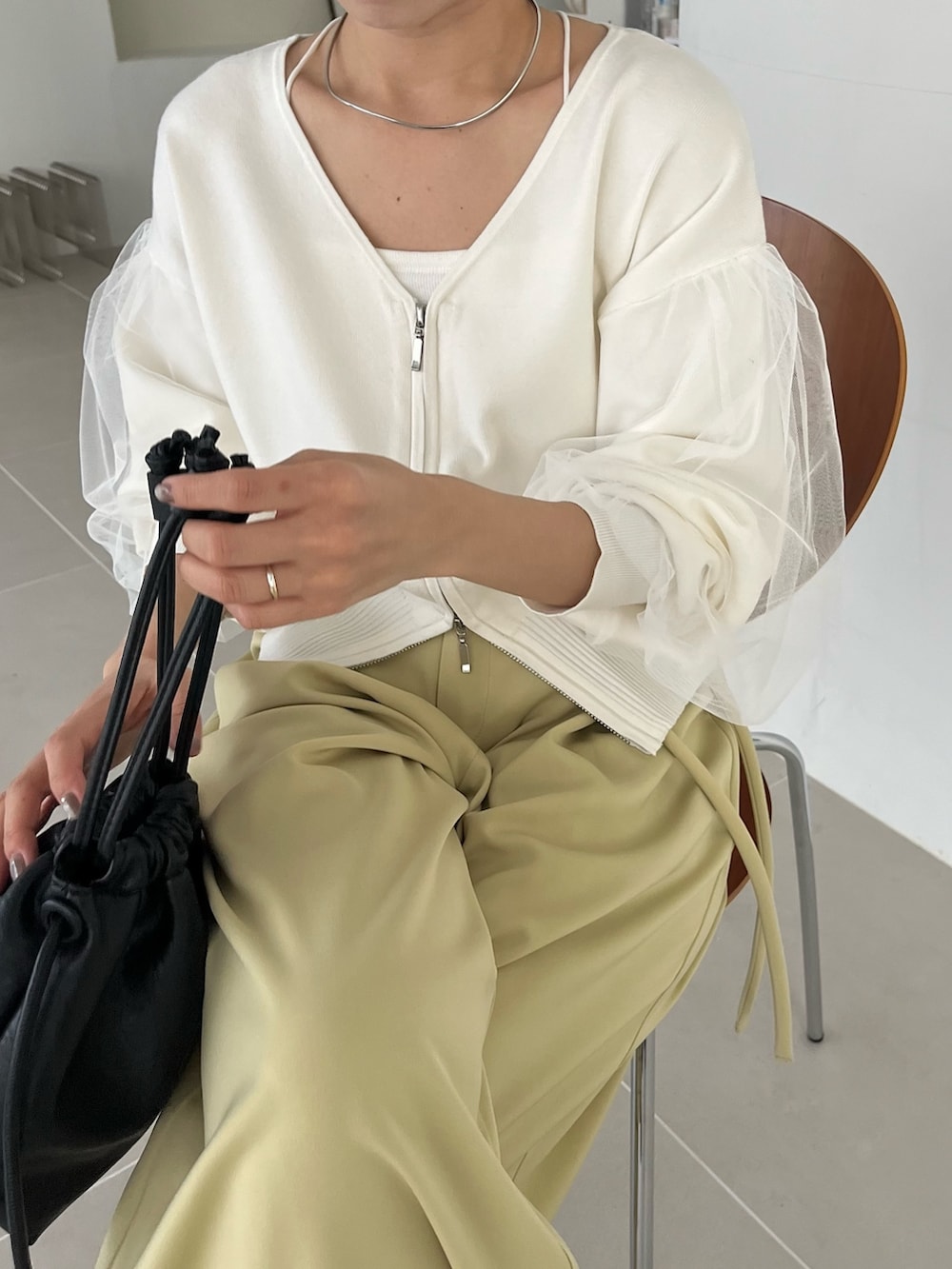 ホワイト系のカーディガン/ボレロ、グリーン系のその他パンツ、ブラック系のブーツを着用したレディースの冬コーディネートの4枚目の写真