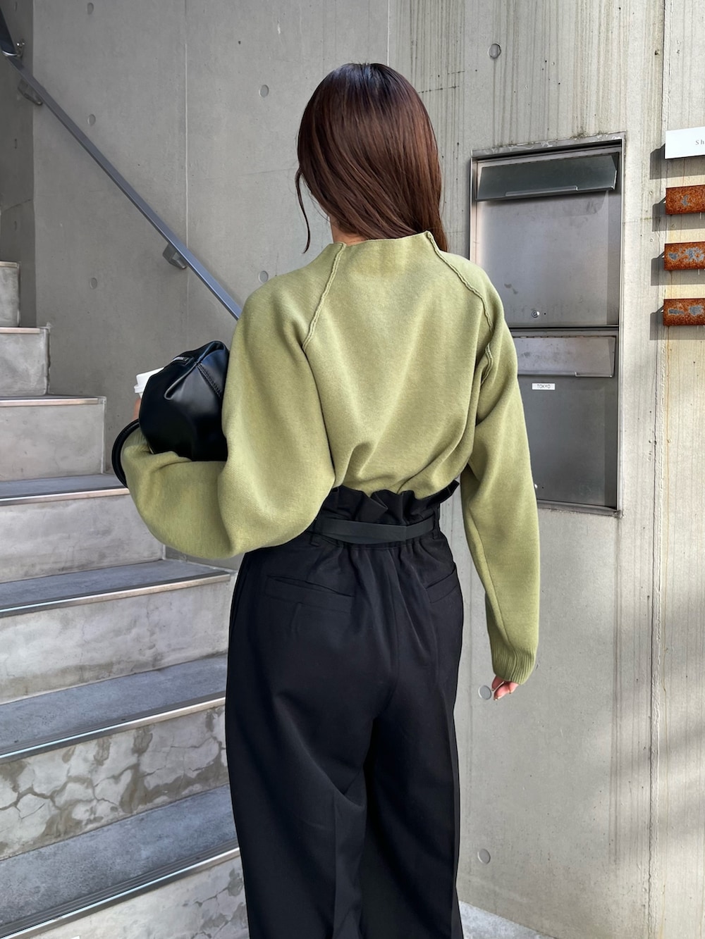 ブラック系のその他パンツ、グリーン系のニット/セーター、ブラック系のトートバッグを着用したレディースの冬コーディネートの7枚目の写真