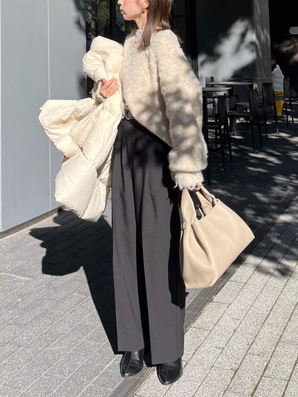 ベージュ系のニット/セーター、ブラック系のスラックス、ブラック系のブーツを着用したレディースの冬コーディネートの6枚目の写真