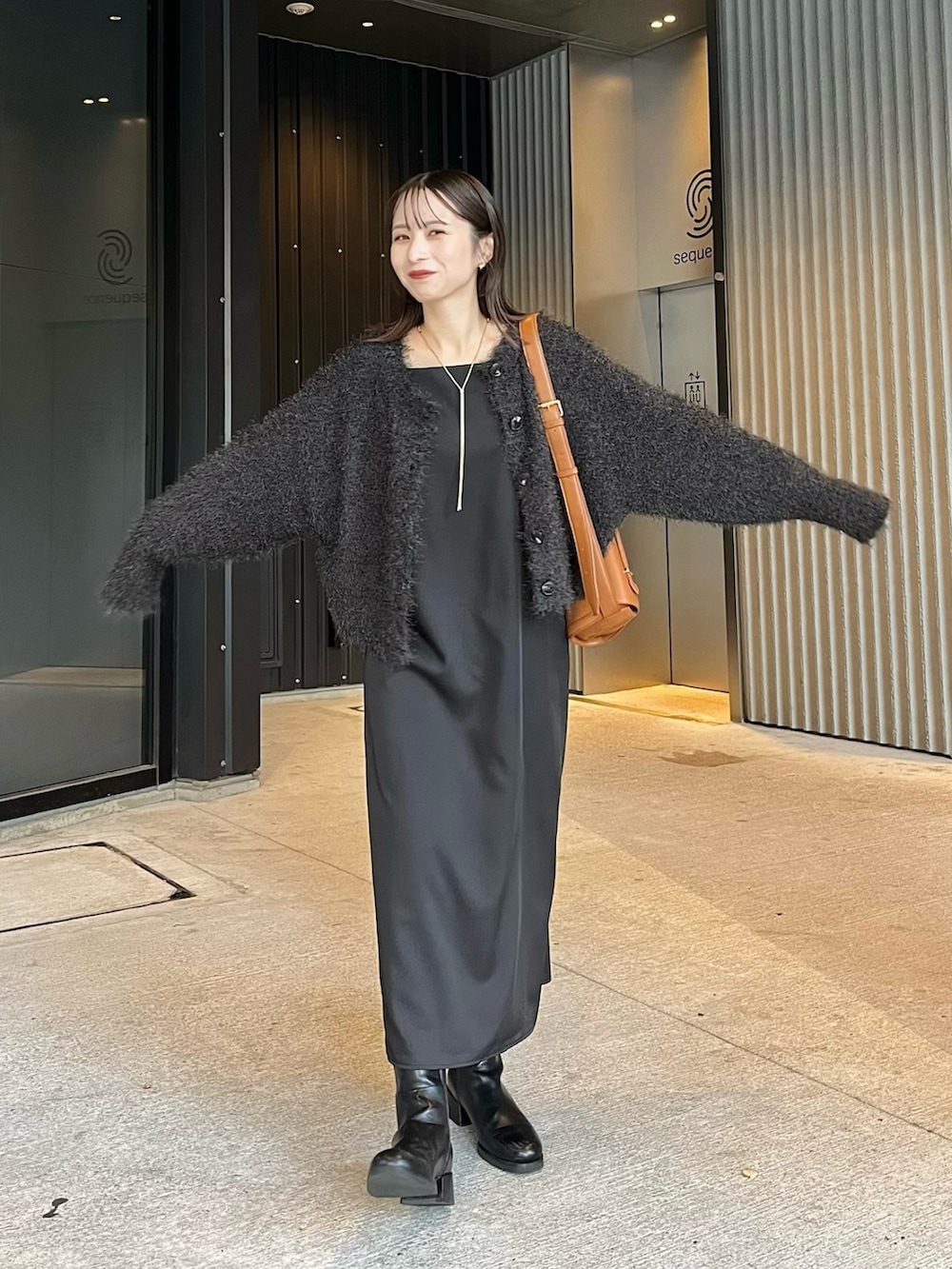 ブラック系のブーツ、グレー系のカーディガン/ボレロ、ブラック系のワンピースを着用したレディースの秋コーディネートの2枚目の写真