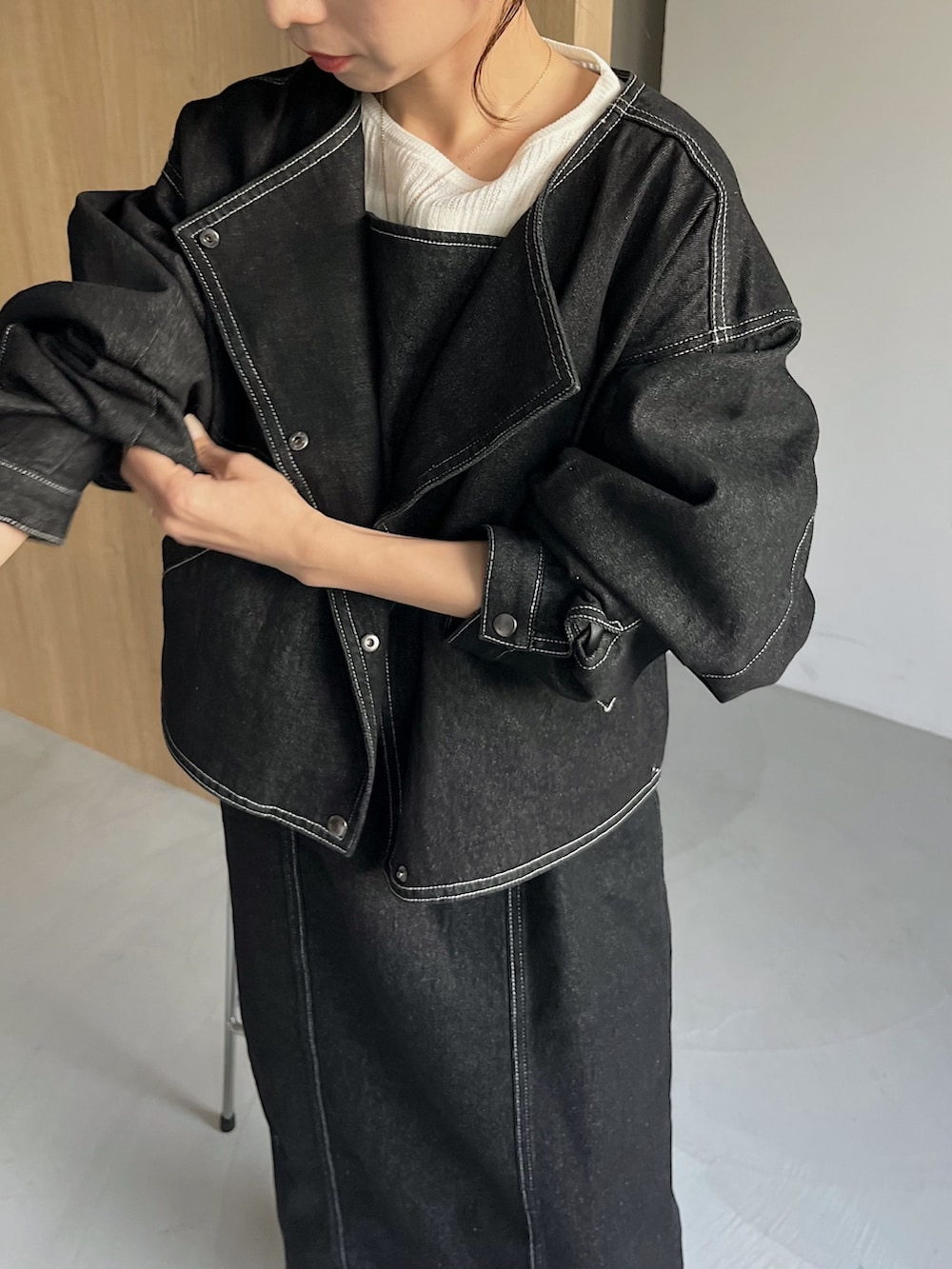 ブラック系のワンピース、ブラック系のデニムジャケット、ホワイト系のニット/セーターを着用したレディースの冬コーディネートの4枚目の写真